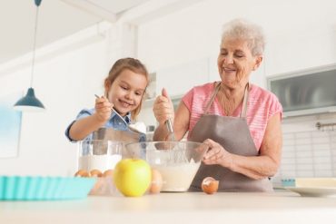 Une personne âgée et sa petite fille préparent une recette lors d'une session de cuisine thérapie