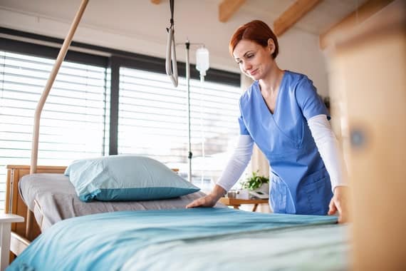 Une aide soignante vient de changer les draps du lit d'un patient ayant une escarre de stade 4