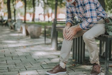 Un homme senior ressent une douleur au genou car il souffre de rhumatisme