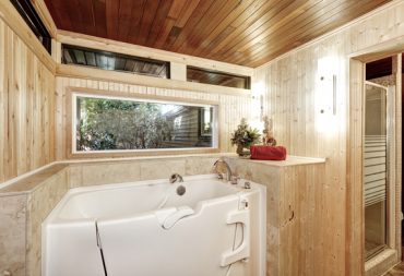 Photo d'une baignoire avec porte installée dans une salle de bain en bois