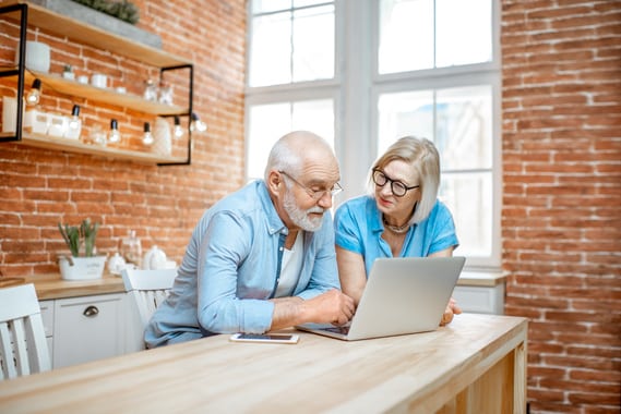 Un couple de seniors utilisent internet pour faire des achats en ligne