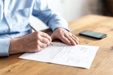 Un senior signe un contrat assurance obsèques
