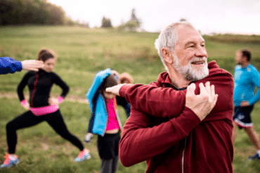 Un senior pratique une activité physique adaptée en plein air