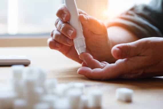 une femme âgée souffrant de diabète de type 1 vérifie son taux de glycémie avec un glucomètre